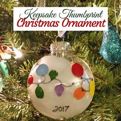 a christmas ornament hanging from a tree with the words keepsake thumpprint christmas ornament on it