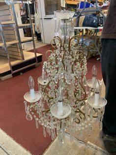 a chandelier made out of glass is on display in a store with people looking at it