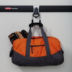 an orange duffel bag hanging on a wall