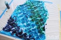 an art project is being made with blue and green dyes on the paper towel