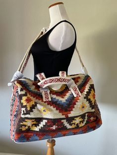 **Ruggine* Handmade ethnic Navajo-inspired pattern with short straps and adjustable shoulder straps featuring two slip pockets and zipper pocket inside fully fine cotton duffel bag *Shell: 100% Cotton *Lining: 100% Polyester *APPROX. L 15 1/2" W 19" Depth 7 1/2" Strap 49" Handle 17 1/2" *Made In India Boho Weekender Bag, Brown Bohemian Weekender Shoulder Bag, Bohemian Weekender Shoulder Bag For Travel, Brown Bohemian Weekender Bag For Everyday Use, Bohemian Shoulder Weekender Bag, Bohemian Brown Weekender Bag For Everyday, Artisan Shoulder Bag With Adjustable Strap For Vacation, Bohemian Duffle Bag With Leather Handles, Bohemian Duffle Bag With Leather Handles For Daily Use