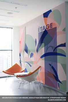 an empty room with two chairs in front of a large wall mural that reads etage