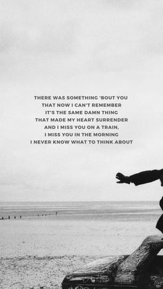 a black and white photo of a man jumping on a rock at the beach with an inspirational quote