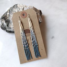 three strands of blue and white seed beaded earrings on top of a brown card