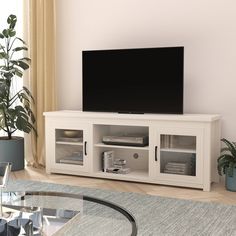 a flat screen tv sitting on top of a white entertainment center in a living room