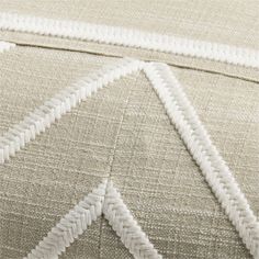 closeup of the stitchs on an upholstered bedding with white piping