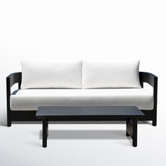 a black and white couch sitting on top of a wooden table next to a coffee table