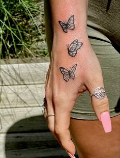 butterfly, butterflies, hand tattoo, tattoo, ink, black, white, fine line tattoo, hand, butterfly tattoo, nails, pink nails, jewelry, rings, tree of life, snake ring, new ink, simple tattoo, girly tattoo, feminine tattoo, tattoo idea, highlight, shading, artist Tattoo Ideas Hand Butterfly, Small Left Hand Tattoos For Women, Butterfly Tattoo Side Of Wrist, Butterflies Tattoo On Hand, Black Butterfly Hand Tattoo, Tattooed Hands Women, Small Butterfly Hand Tattoos For Women, Small Butterfly Forearm Tattoo