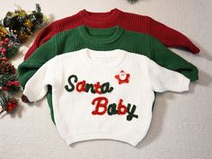 Introducing our personalized baby sweater! Made of high-quality cotton, this cute and practical sweater is the perfect gift. Our unique design keeps your little one comfortable and stylish. It is suitable for any occasion and is a warm hug for your baby. Material: Cotton, Yarn Customization Options: Please provide the yarn color, the slogan "Santa baby" is fixed in red and green color as shown in the picture. If you want some Christmas accessories, please contact me. Processing Time: Within one Baby Name Sweater, Name Sweater, Pull Bebe, Embroidered Christmas, Baby Sweater, First Birthday Gifts, Christmas Accessories, Santa Baby, Warm Hug