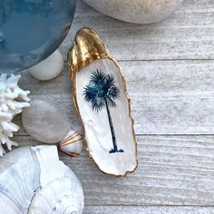 shells and seashells on a wooden table with palm tree painted on the shell