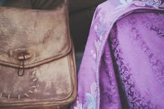 two purses sitting next to each other on the ground