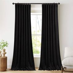 the black curtains are hanging in front of a window