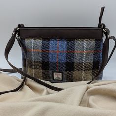 Our Harris Tweed Large Shoulder Bag is a brilliant size with a durable style, that can be used every day. The shoulder bag has one main compartment, secured with a zip. Inside this Harris Tweed bag there are open pockets for phones and essentials as well as a small zip compartment. This bag has a short shoulder strap as well as a longer detachable strap that you can wear across your body. Large Shoulder Bag Dimensions: 20cm x 30cm x 9cm The vegan leather trim colour will differ depending on the Brown Tweed Shoulder Bag For Everyday Use, Rectangular Tweed Shoulder Bag For Travel, Rectangular Tweed Shoulder Bag For Everyday Use, Rectangular Tweed Shoulder Bag For Everyday, Everyday Tweed Crossbody Bag, Brown Tweed Shoulder Bag For Travel, Everyday Tweed Satchel Shoulder Bag, Harris Tweed Bag, Colours Of Nature