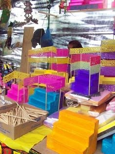 there are many different colored chairs on the street market stall with sticks sticking out of them