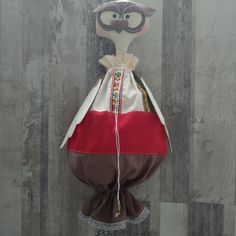 a stuffed animal wearing a red and brown dress