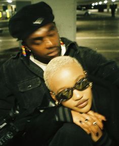 a man and woman sitting next to each other in front of a parking garage door