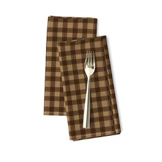 two brown plaid napkins with a fork on them