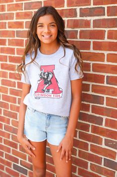 Youth t-shirt with vintage Alabama logo Unisex Model is size 10-12 Collegiate Summer T-shirt, Collegiate Pre-shrunk T-shirt For Summer, Pre-shrunk Collegiate T-shirt For Summer, Spring Fan Merchandise T-shirt, Spring Fan Apparel Tops, Gray Collegiate Short Sleeve Top, Gray Short Sleeve Collegiate Top, Gray Casual T-shirt For Fans, Casual Gray T-shirt For Fans