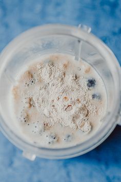 an overhead view of a blender with ingredients in it on a blue table top