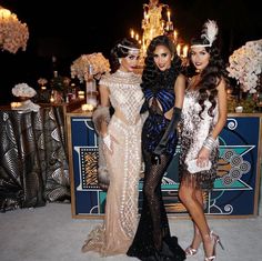 three beautiful women standing next to each other in front of a table with flowers and candles