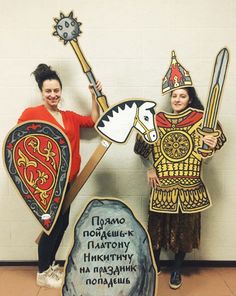 two people in costumes standing next to each other and holding up signs with words on them