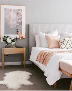 a bedroom with a bed, nightstand and pictures on the wall above it that is decorated in neutral colors