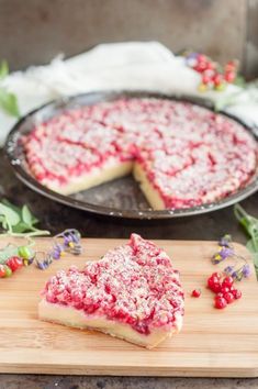 a piece of cake sitting on top of a wooden cutting board next to a pie pan