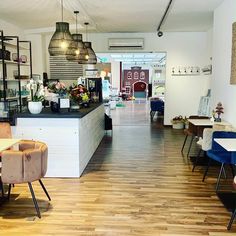 the inside of a restaurant with tables, chairs and shelves on either side of the counter