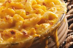 macaroni and cheese casserole in a glass dish on a wicker table