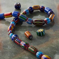 multicolored glass bead necklace and earring set sitting on top of a table