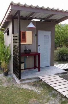 a small shed with a red table in the front and white door on the side