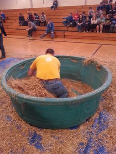 a man sitting in a green tub filled with hay