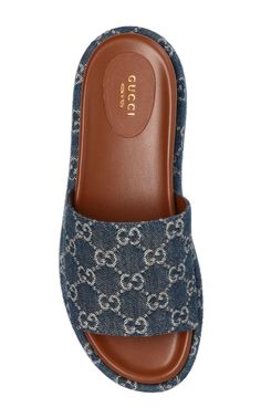 These blue Gucci Angelina 55 platform sandals are made in Italy. They feature a canvas design with signature GG Supreme patterning, a brown leather insole and a 55 mm flatform. Upper: Cotton, LeatherLining Composition: Leather 100%Sole Composition: Rubber 100%Slip-onFits true to sizeHeel height: 2.2" /5cmMade in Italy Luxury Platform Slip-on Sandals, Luxury Slip-on Platform Sandals, Luxury Leather Platform Slides, Luxury Slides With Platform And Round Toe, Blue Leather Gucci Sandals, Gucci Blue Leather Sandals, Luxury Platform Slides For Summer, Gucci Luxury Sandals With Cushioned Footbed, Designer Flat Heel Platform Sandals