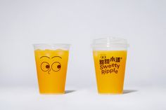 two cups with faces drawn on them sitting next to each other in front of a white background