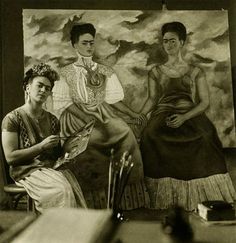 two women sitting next to each other in front of a painting with clouds above them