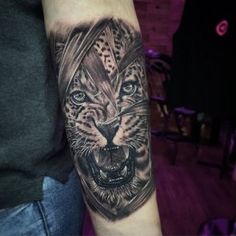 a man with a tattoo on his arm that has a tiger's head in the middle