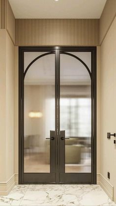 an open door leading to a living room with marble flooring and walls in the background