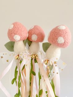 two pink and white mushrooms on top of each other with ribbons tied around the stems