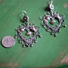 A beautiful, large sterling silver earring made in Taxco, Mexico. This is a very pretty heart shaped earring with a pair of pájaros or lovebirds on the sides of the heart and is then decorated with filagree and cup dangles. This is the type of jewelry that Frida Kahlo loved and wore often. They are very shiny and absolutely stunning! Matching necklace will be in stock soon. state of origin: Taxco, Guerrero dimensions: approx 3" long by 1.75" wide Traditional Silver Heart Earrings, Handmade Sterling Silver Heart Earrings, Vintage Sterling Silver Pierced Heart Earrings, Vintage Style Sterling Silver Pierced Heart Earrings, Handmade Sterling Silver Heart Earrings For Wedding, Bohemian Sterling Silver Heart Earrings, Handmade Bohemian Sterling Silver Heart Earrings, Bohemian Handmade Sterling Silver Heart Earrings, State Of Origin