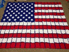 an american flag quilt is displayed on the floor