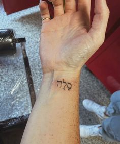 a person with a small tattoo on their wrist holding up the word,'i love you