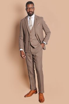 With its neutral colour and slim fit, this tailored suit is a three-piece you'll look forward to showing off. The style boasts the bespoke MD circle print lining, notch lapels with MD badge and is trimmed with marbled buttons. Features Slim fit Single-breasted waistcoat Notch lapel Double back vent Four button cuff Double button blazer fastening Complimentary pocket square Waistcoat adjuster straps Functional inside and outside pockets to the blazer Style Tip | Accessorise with tan to match the Linen Suit Brown Shoes, Taupe Suit Wedding, Taupe Tuxedo Wedding, Taupe Suits Wedding Men, Light Brown Groomsmen Suits, Dark Tan Suit, Tan Suits For Wedding