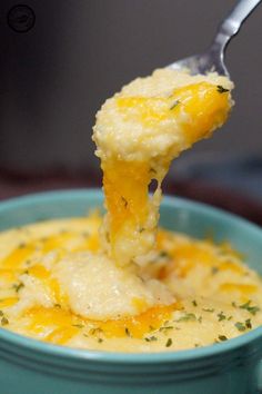 a spoonful of cheesy potato soup in a blue bowl