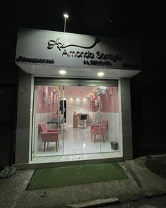 the entrance to an artisan salon with pink chairs and tables in front of it