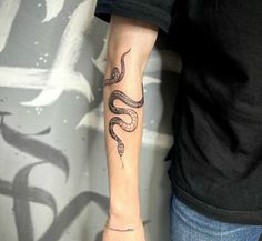 a man with a snake tattoo on his arm