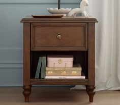 a nightstand with books and a white horse figurine on top