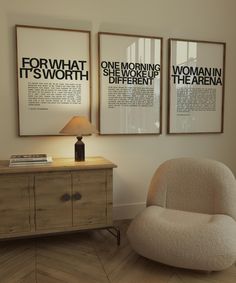 two framed posters hang on the wall above a dresser with a chair in front of it