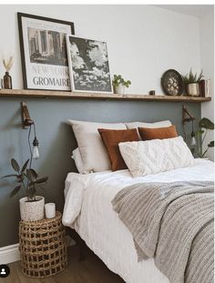 a bed with white sheets and pillows on top of it next to a wooden shelf