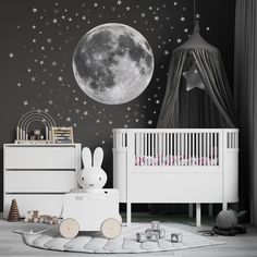 a child's room with stars and moon wallpaper, white crib bedding, wooden toy car