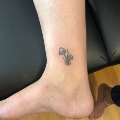 a woman's foot with a small flower tattoo on her left side calfocks